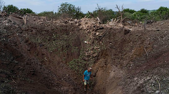 A resident walks into a crater caused by a missile strike in Druzhkivka, eastern Ukraine, last week.