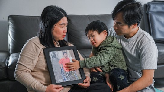 Lily Lumintang, husband Martin Cahyo, and their son Raphael, 3, with a photo of their other son Jonathan 13.