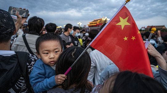 A boy holds a Chinese flag as people gather next to Tiananmen Square on October 1. 