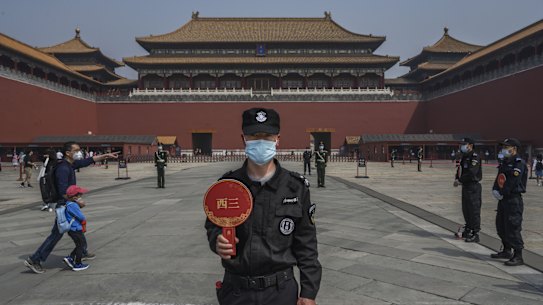 A Chinese guard wears a protective mask as he stands at the entrance to Beijing's Forbidden City. 