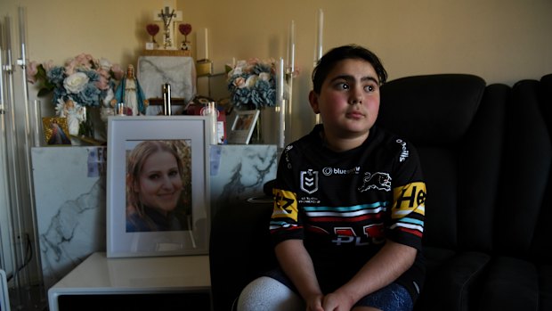 Sea World helicopter crach survivor Nicholas Tadros at home by the portrait of his late mother, Venessa. Nicholas is a Panthers fan and has been invited by the NRL to watch Sunday’s grand final at Accor Stadium.