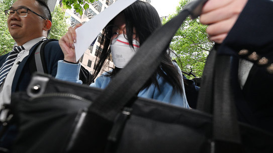 Jin Wang (centre) outside the Melbourne Magistrate’s Court, out on bail.