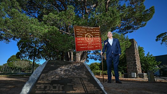 David Laird stands ready beneath the Lonesome Pine with “Clarrie’s Flag”, the banner of the 7th Battalion, for the early Anzac ceremony at Wattle Park.