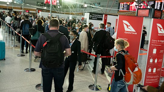 Qantas disruption-weary passengers queue at the domestic check in terminal at Sydney airport.
