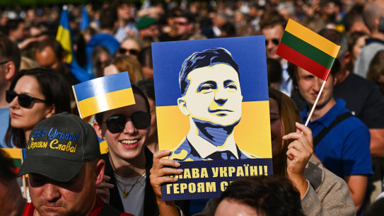 A woman holds a banner with the President of Ukraine, Volodymyr Zelensky portrait during the Raising the Flag for Ukraine NATO event in Vilnius, Lithuania.