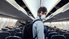 Shot of a young man wearing a mask and boarding an plane