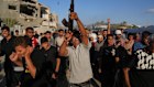 A man shoots into the air during the funeral of Palestinians killed by Israeli fire, in Deir al-Balah, Gaza on Sunday.