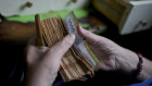 A worker counts money at a grocery store in Buenos Aires.