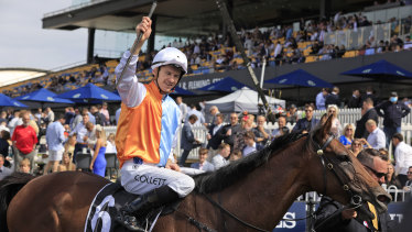 Jason Collett salutes the Rosehill crowd as he returns to scale after his victory.