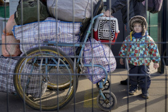 A family crosses from pro-Russian separatists co<em></em>ntrolled territory to Ukrainian government co<em></em>ntrolled areas in Stanytsia Luhanska, the o<em></em>nly crossing point open daily, in the Luhansk region, eastern Ukraine, Tuesday, Feb. 22, 2022.