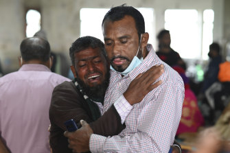 A man consoles a relative who could not find his 5-year-old son after the ferry fire.