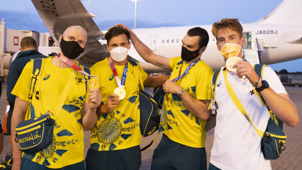 Gold medallist rowers, from left, Spencer Turrin, Alexander Hill, Alexander Purnell and Jack Hargreaves hold up their Tokyo Olympic medals on arrival back in Sydney on Sunday.