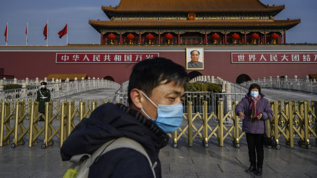 People wearing face masks at Tiananmen Square in Beijing: The rapid spread of the pneumonia-like disease has virtually shut down China.