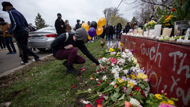 People place flowers during a vigil for Daunte Wright in Brooklyn Centre.