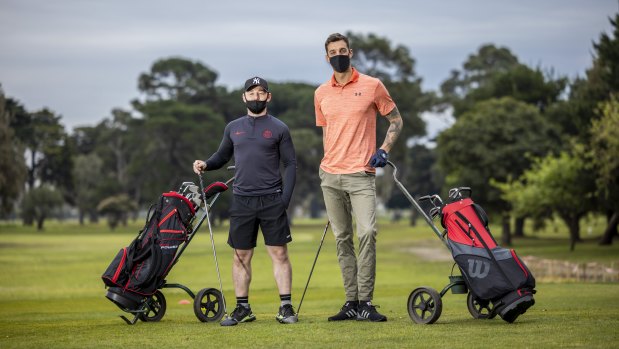 Shane Nolan (left) and Anthony Carden hit Albert Park Golf Course on Wednesday, shortly after restrictions eased. 