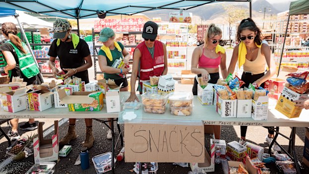 Volunteers sort through donated food items at an emergency aid distribution point for victims of last week’s wildfire in Lahaina, on the Hawaiian island of Maui.