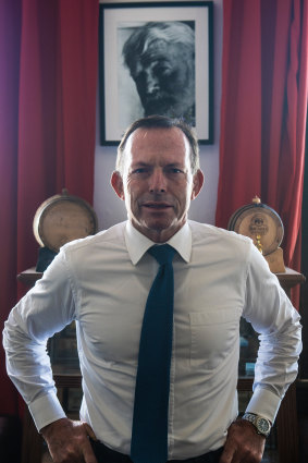 Former prime minister, Tony Abbott, in front of a portrait of Ernest Hemingway.