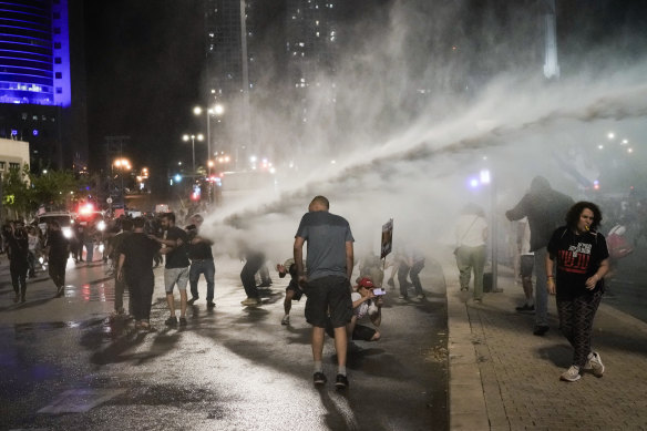 Police use a water cannon to disperse anti-government protesters blocking a road in Tel Aviv, Israel.