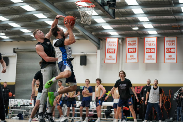 Melbourne United guard Matthew Dellavedova attempts a lay-up while being pressured by NBA forward Jack White at training on Wednesday.