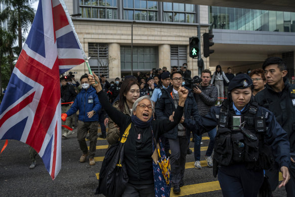 Activist Alexandra Wong, also known as Grandma Wong, holds a flag of Britain outside West Kowloon Magistrates’ Courts where the trial is taking place.