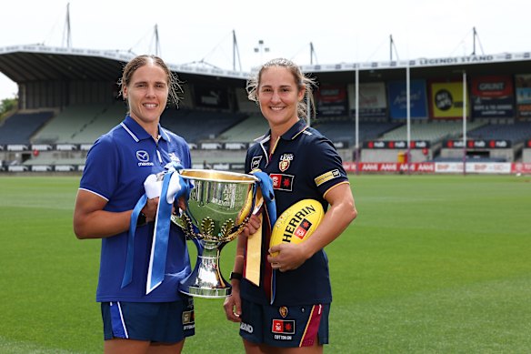 Jasmine Garner of the Kangaroos and Brisbane Lions counterpart Breanna Koenen hold the premiership cup.