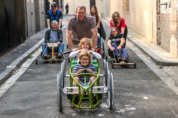 Pete Furlong with his children, Orly and Lenni, lead a pack of Queensberry Cup billycart racers.