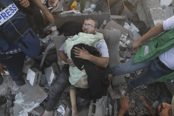 An injured Palestinian man hugs an injured relative after being rescued following Israeli airstrikes on Gaza City on Wednesday.