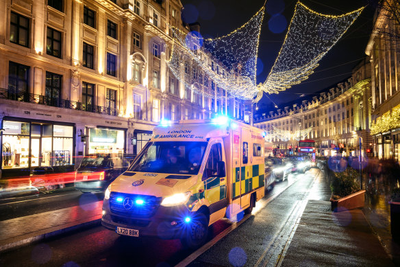 An ambulance queues in traffic beneath the Christmas decorations on Regent Street in London.