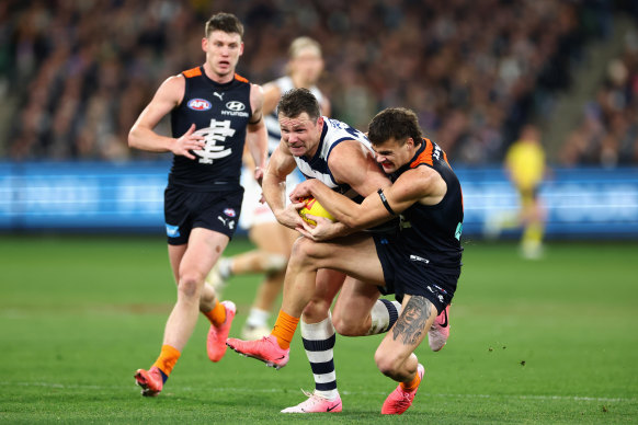 Patrick Dangerfield of the Cats is tackled by Lachlan Cowan of the Blues.