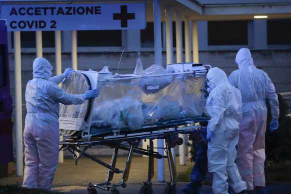 A patient in a biocontainment unit is carried on a stretcher at the Columbus Covid 2 Hospital in Rome, a major hot spot in March 2020.