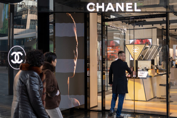 A man enters a Chanel shop in the Sanlitun shopping district. Many customers are still spending, others are trading in their luxury goods.