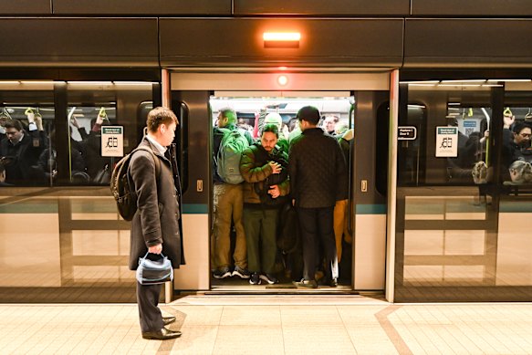 A commuter waits for the next train at Crows Nest station because he cannot get on a packed service.
