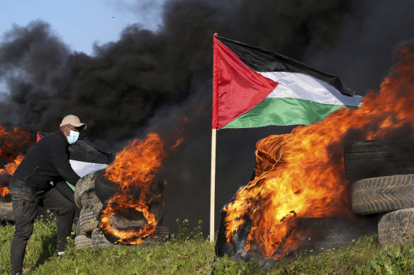 Demonstrator burns tires during a protest against the Israeli military raid.