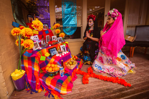 Flor Labana and Susi Tovar at the altar to loved ones at Pedro Chan’s house in Dingley Village.