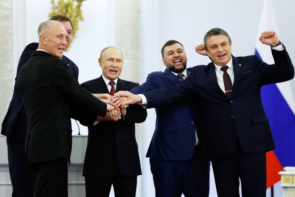 Moscow-appointed head of Kherson Region Vladimir Saldo, Moscow-appointed head of Zaporizhzhia region Yevgeny Balitsky, Russian President Vladimir Putin, Denis Pushilin, leader of self-proclaimed of the Donetsk People’s Republic and Leonid Pasechnik, leader of self-proclaimed Luhansk People’s Republic pose for a photo during a ceremony to sign the treaties for four regions of Ukraine to join Russia.