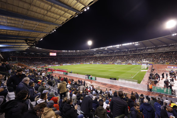 Fans wait in the stands after suspension of the match.