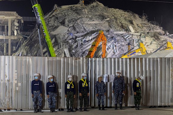 Thai army soldiers stand guard as rescuers work at the site of an under-construction high-rise building that collapsed on Friday.