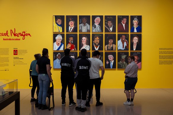 Gallery visitors view artwork by Vincent Namatjira at the National Gallery of Australia this month. Gina Rinehart’s portrait is in the middle row, third from left. 