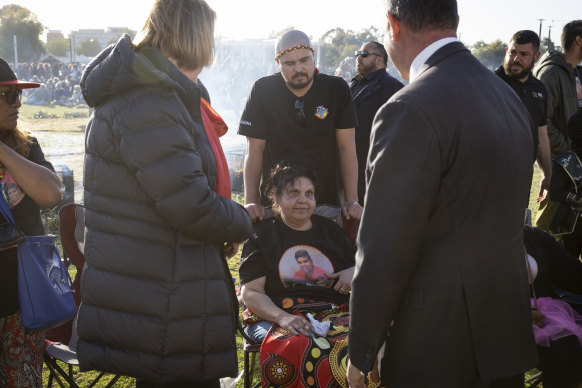 Mechelle Turvey is greeted by Police Minister Paul Papalia at the vigil on Monday.