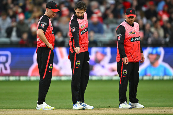 Renegades players look at the pitch after play was called off on Sunday night.