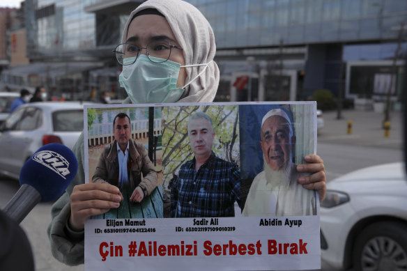 Uighur protester Shemsiye Ali holds photographs of relatives she says they have not heard from in years near the Chinese Embassy in Ankara, Turkey.