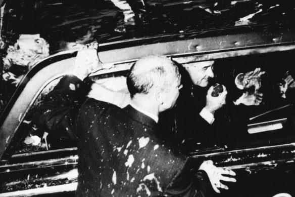 US president Lyndon Johnson drives through Melbourne on October 21, 1966. A member of his security detail bears the brunt of paint thrown at the presidential limousine by opponents of the Vietnam War.