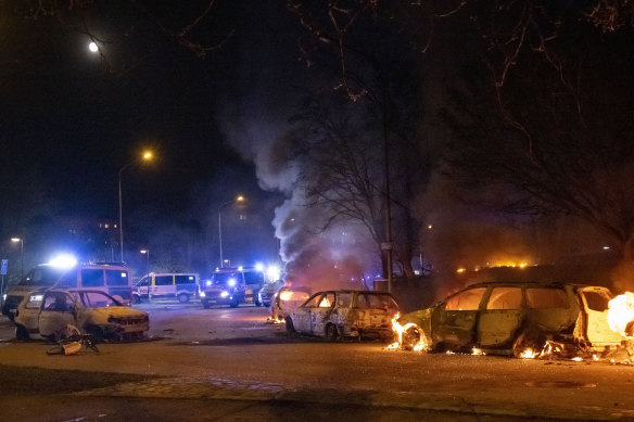 Cars are engulfed by flames after protests broke out at Rosengard in Malmo.