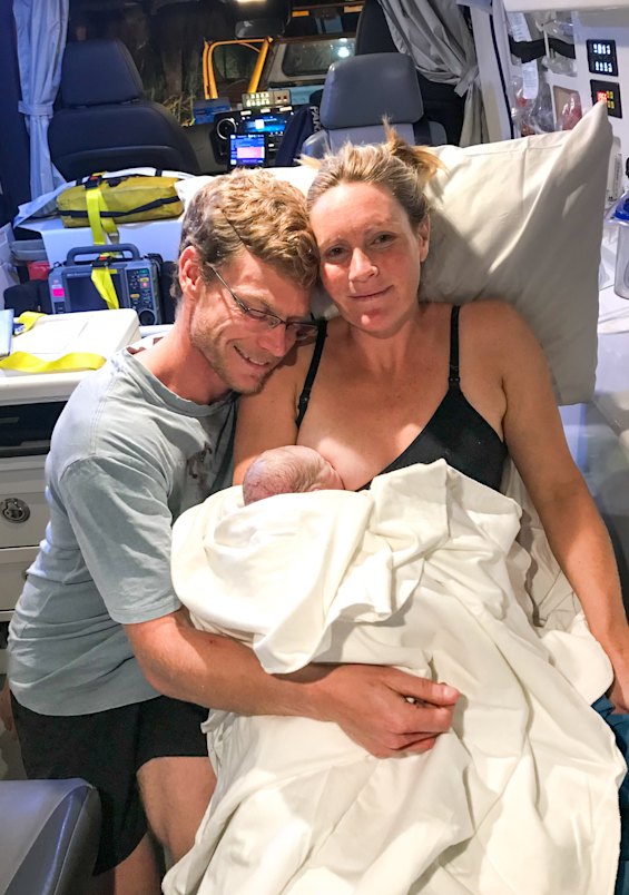 Anja and Ryan Adams with their son Soli in the back of the ambulance after Soli’s roadside birth.