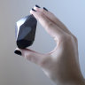 An employee of Sotheby’s Dubai presents a 555.55 Carat Black Diamond “The Enigma” to be auctioned at Sotheby’s Dubai gallery, in Dubai, United Arab Emirates, Monday, Jan. 17, 2022. (AP Photo/Kamran Jebreili)