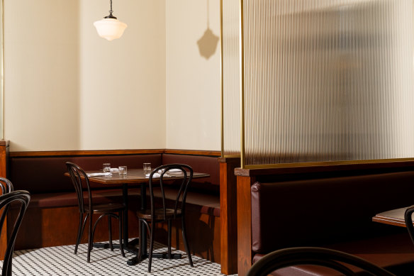 At Winston’s, the floors have black and white tiles and fluted glass separates the booths. 
