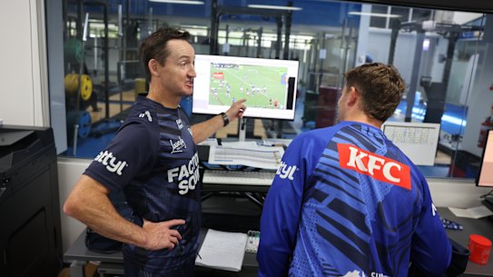 Canterbury Bulldogs half Toby Sexton and assistant coach Jason Taylor work through a video session at Belmore Oval.
