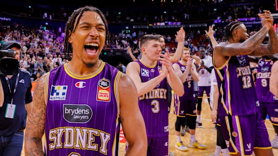 Jaylen Adams celebrates with Kings teammates.
