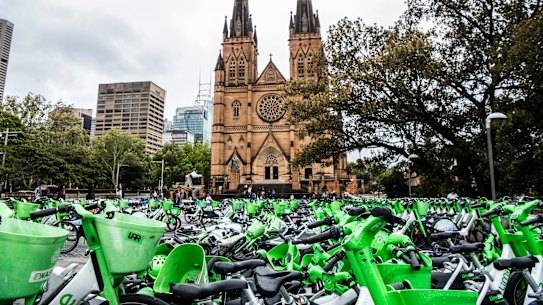 Masses of Lime and other e-bikes in a large fenced off area in front of the Catholic cathedral near Hyde Park.