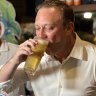 Queensland Premier Steven Miles drinks a beer at the Barrier Reef Hotel in Cairns, as part of a Politics In The Pub campaign event.